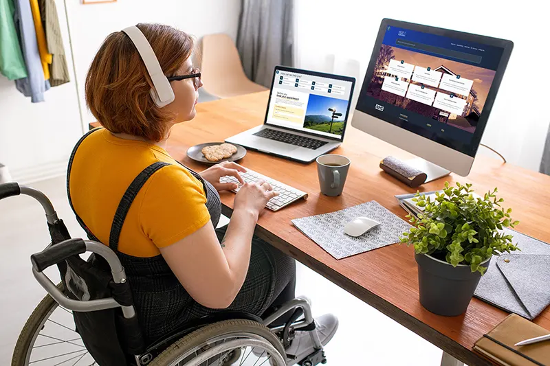 Image of woman sitting in wheelchair at computer screen